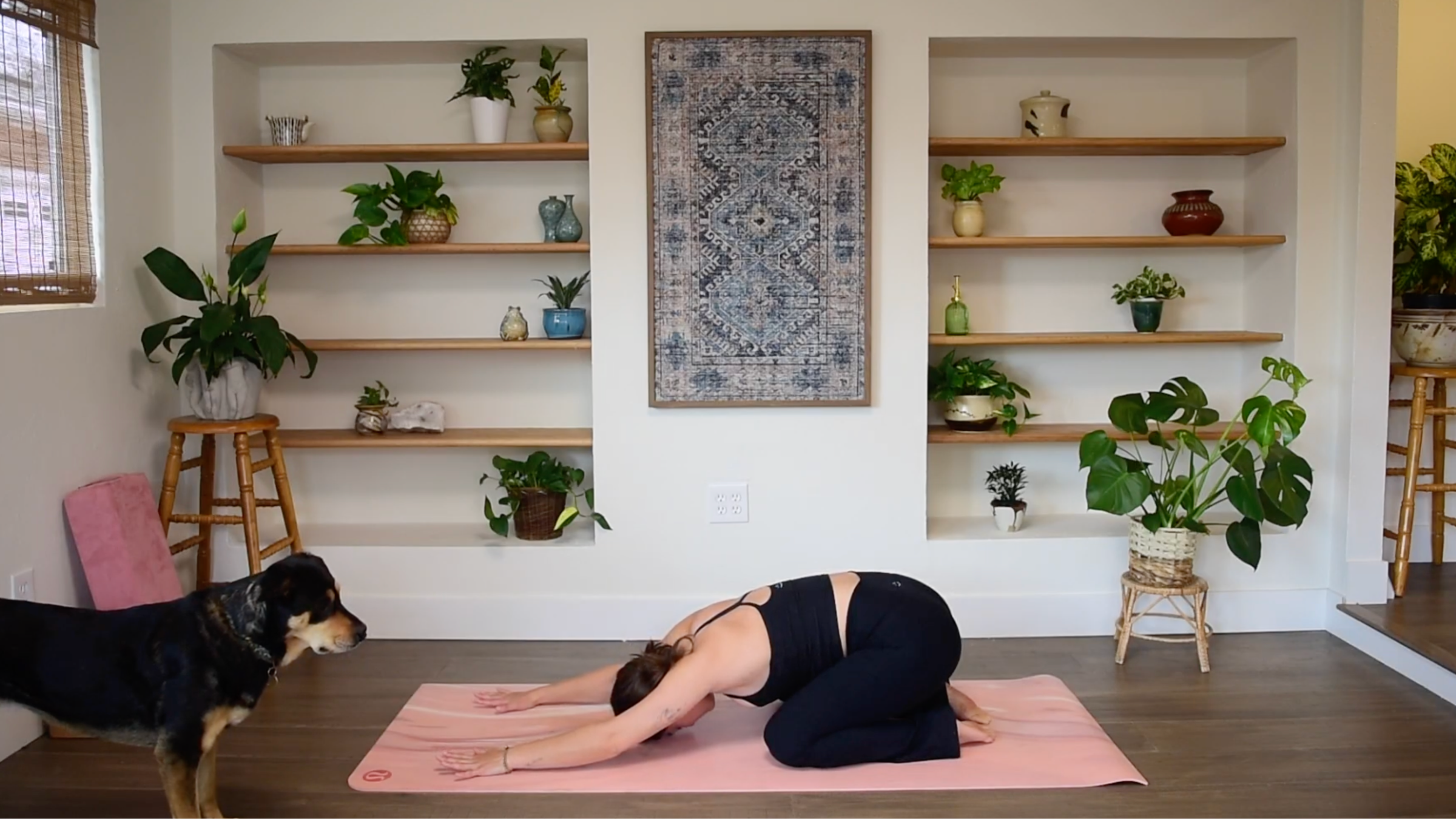 Caitlin K'eli kneeling on a yoga mat with hips resting on heels and forehead resting gently on the mat in Child’s Pose.